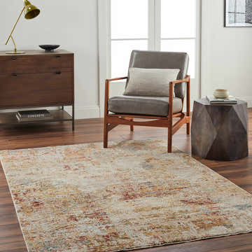 Living room scene with a textured Eula Rug in brick red, mustard, and blue tones. Modern decor with wood furniture and a gray chair. Roomscene-Rectangle