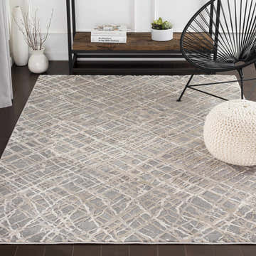 Living room scene with beige and gray Smock Modern Trellis Web Rug, black chair, and white pouf. Roomscene-Rectangle