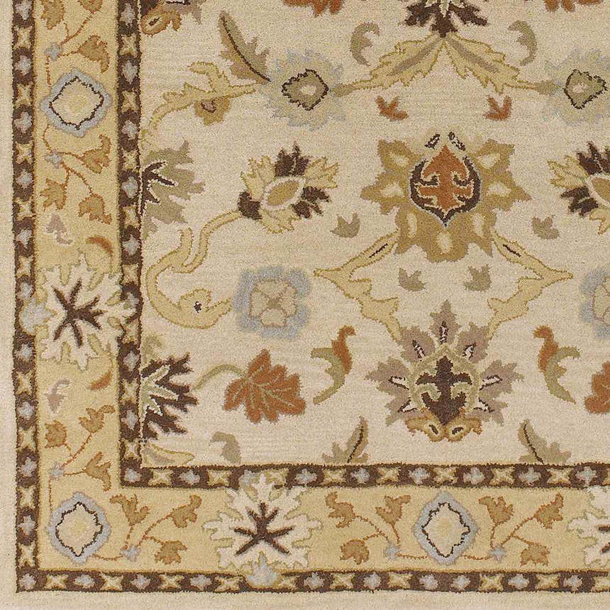 Close up of the hand-tufted Smoot Area Rug. Beige wool rug with traditional floral and leaf pattern in brown, tan, and slate blue. Swatch