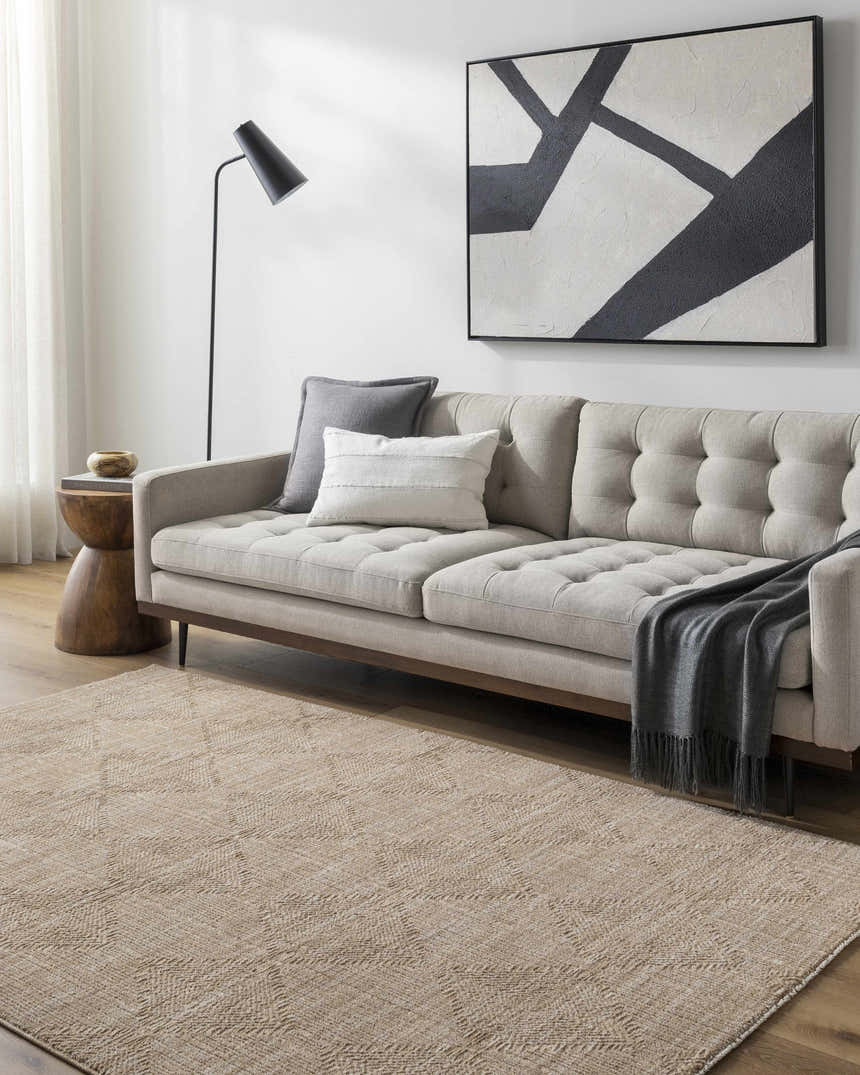 Living room scene with a tan sofa and the Dekan Tan Area Rug in lambswool and light brown. Roomscene-Rectangle