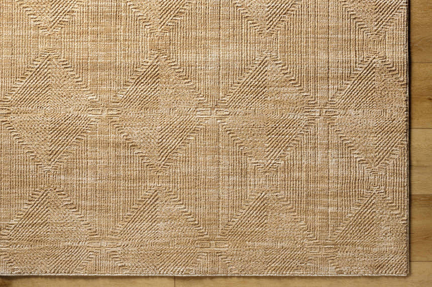 Close up of the Dekan Tan Area Rug featuring a geometric diamond pattern and textured lambswool color. Corner