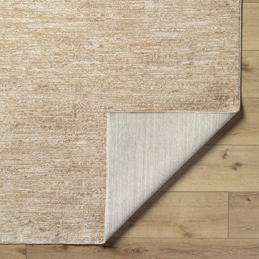 Close-up of the Katia Tan Area Rug showing its khaki and tan textured design and the rug's backing. Fold