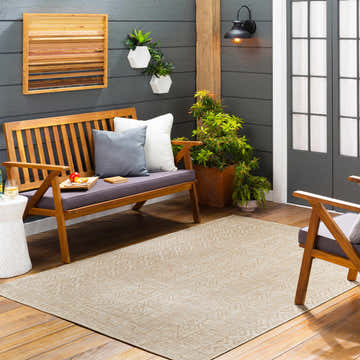 Outdoor patio scene with Epson Beige Indoor & Outdoor Rug, wood bench, plants, and gray siding. Roomscene-Rectangle