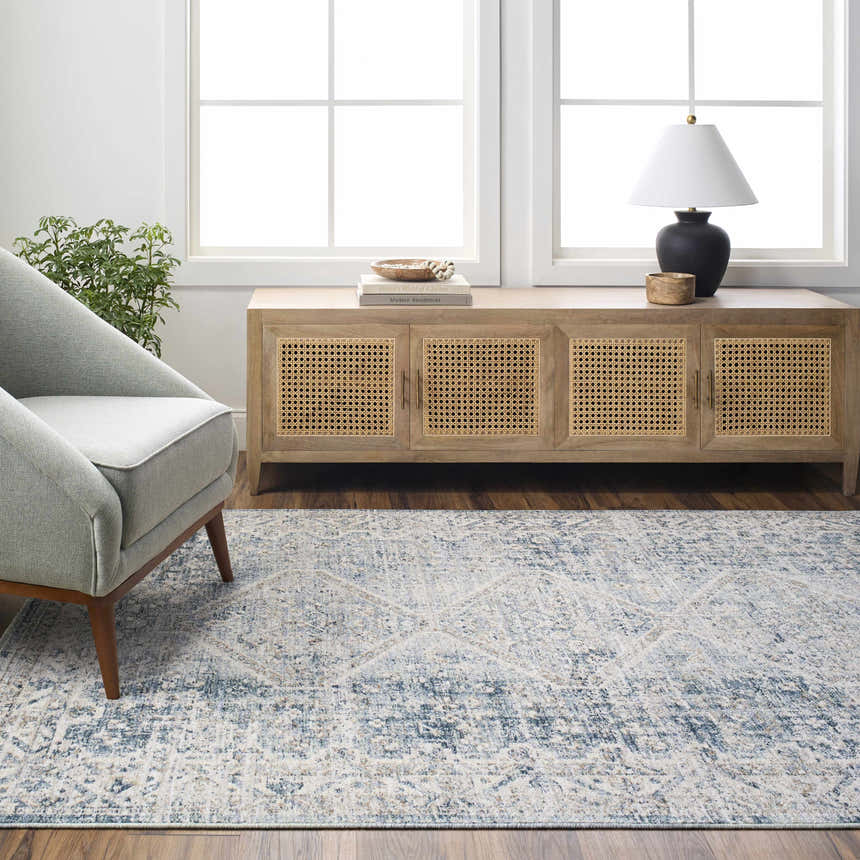 Living room scene with a gray armchair and the light gray Kamea Area Rug. Roomscene-Rectangle