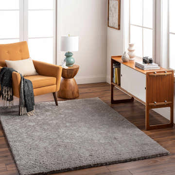 Living room scene with a gray Amnon Area Rug, mustard chair, and mid-century modern cabinet. Roomscene-Rectangle