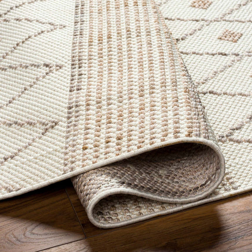 Close-up of the Finch Area Rug showing beige and brown geometric pattern and textured machine woven construction. Fold