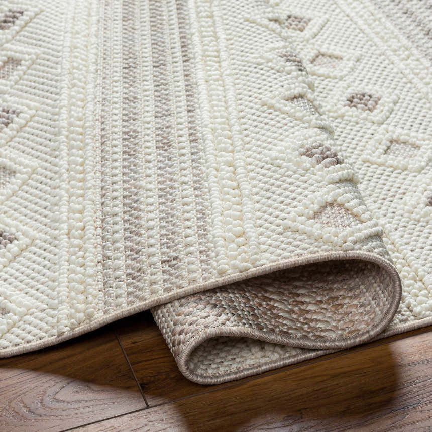 Close-up of the Hideo Area Rug showing its beige, gray, and cream geometric pattern and textured, machine-woven construction. Fold