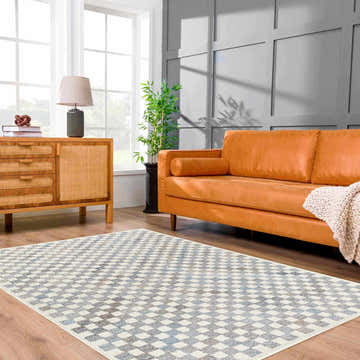 Living room with Halen Gray Checkered Area Rug, wood floors, tan leather sofa, and wood cabinet. Modern style. Roomscene-Rectangle