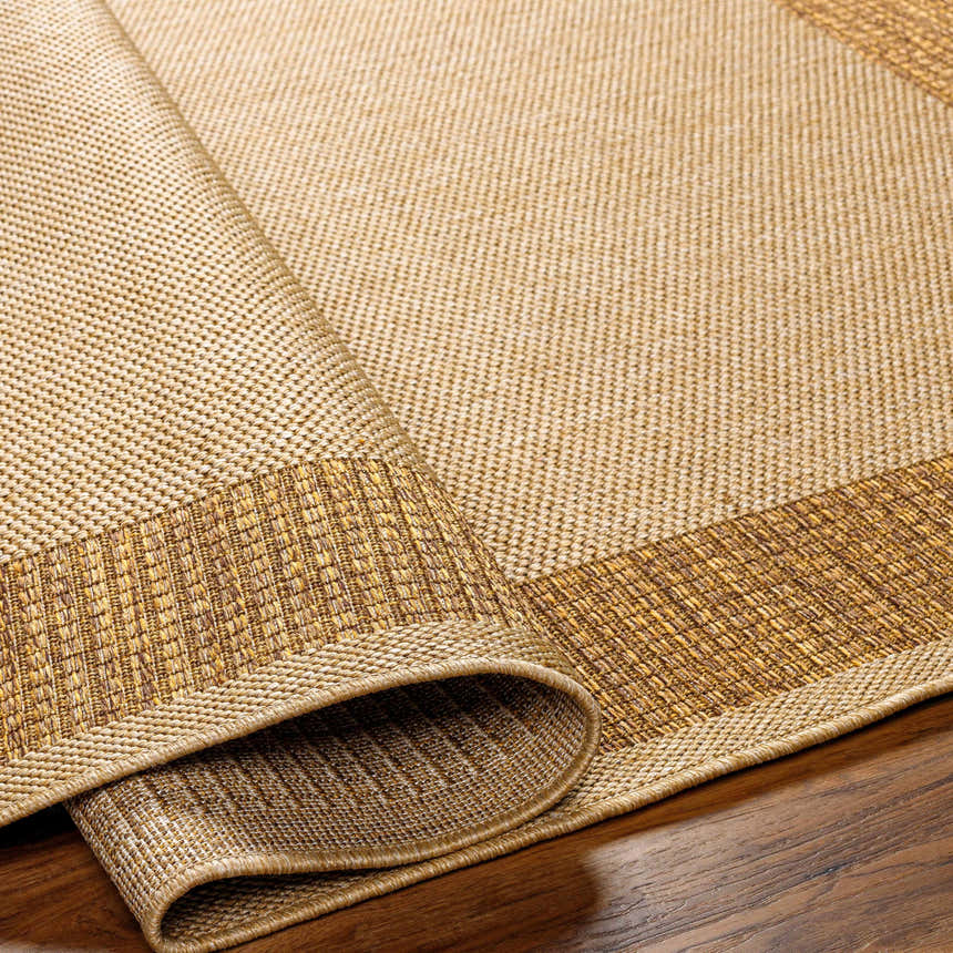 Close-up of the Inigo Flatweave Faux Jute Rug showing its dark beige, brown tones, flatweave texture, and border detail. Fold