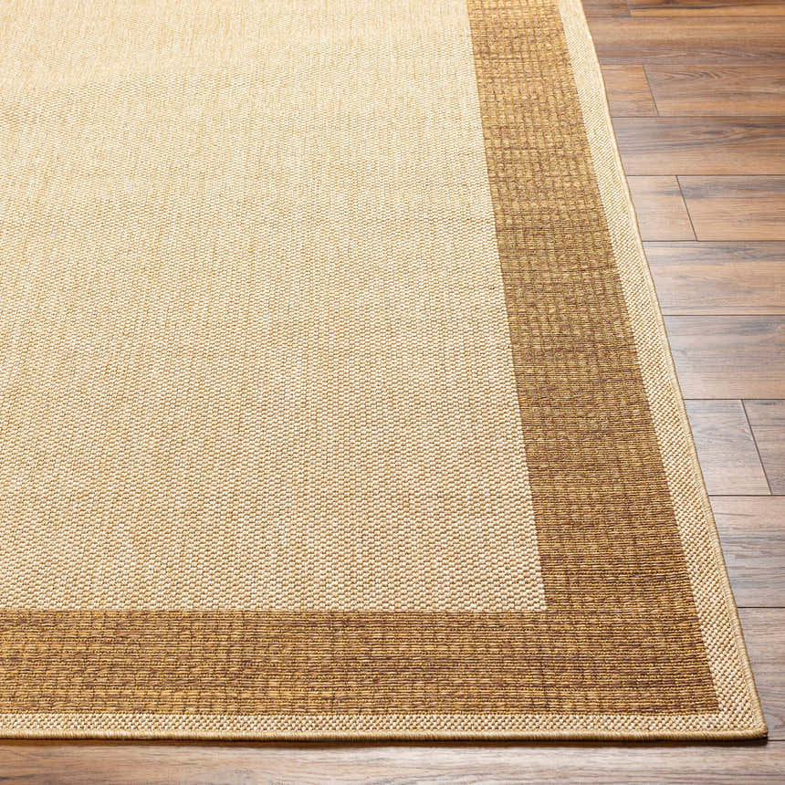 Close-up of the Inigo Flatweave Faux Jute Rug showing its dark beige center and dark brown border on wood floors. Front