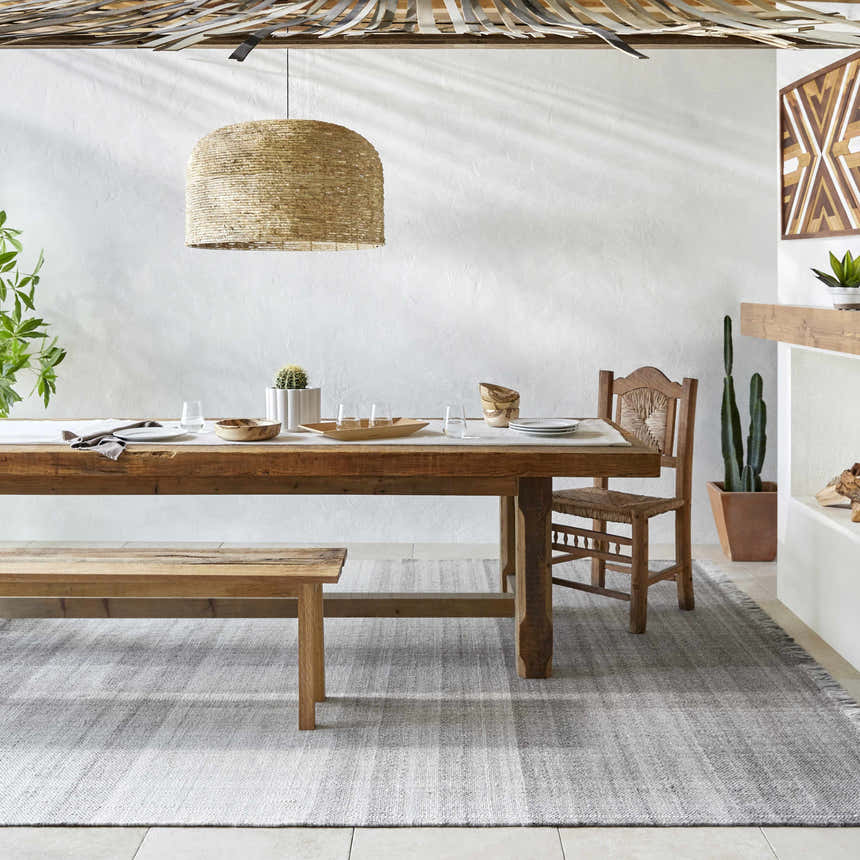 Farmhouse dining room with a light gray Fiora Area Rug, wood table, bench, and woven pendant light. Roomscene-Rectangle