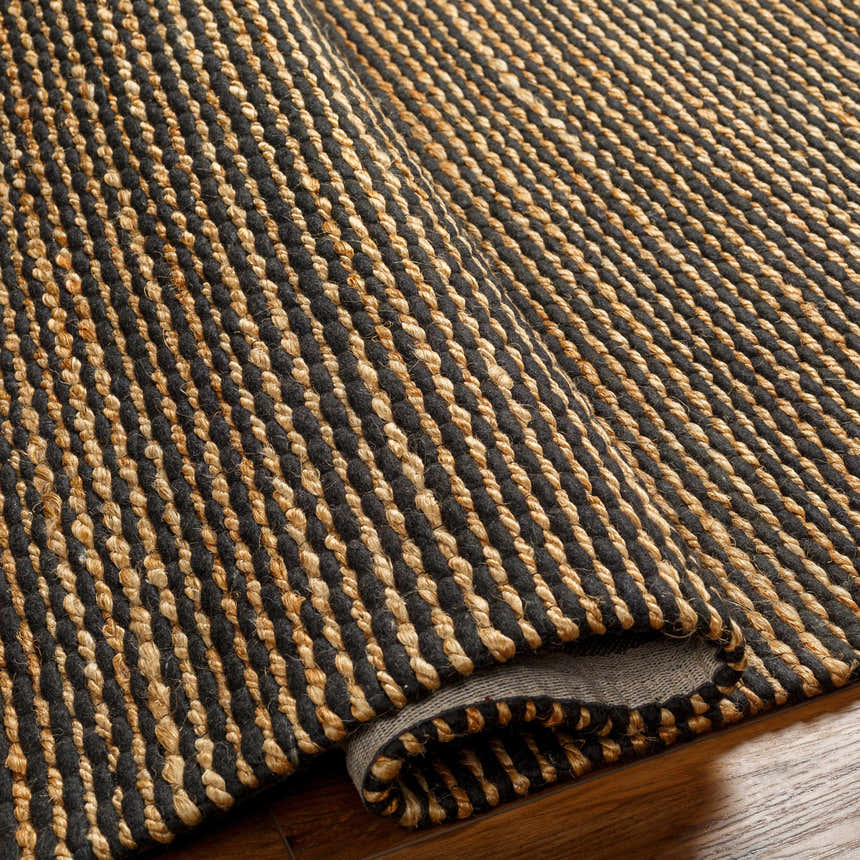 Close up of the hand woven Riki Black Area Rug showing jute texture and striped design. Fold