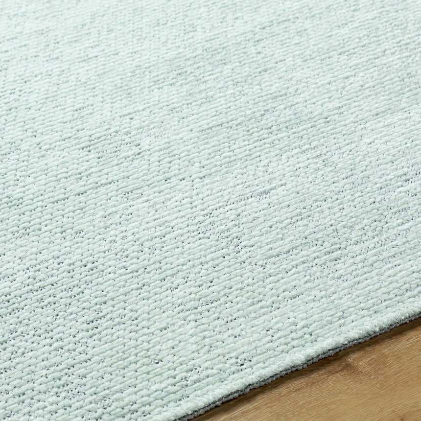 Close-up of the Isako Seafoam Solid Washable Area Rug showing its soft texture and subtle seafoam green color. Texture