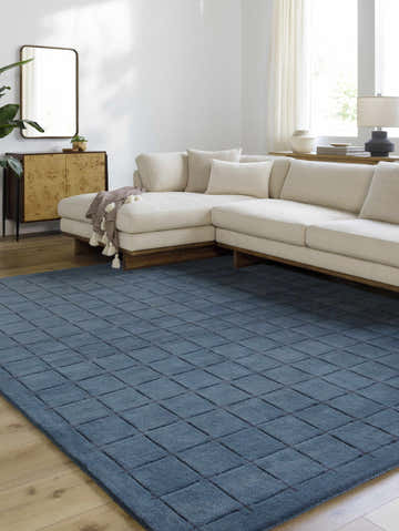 Living room scene with a cream sectional sofa and the Sanvi Navy Wool Area Rug with a geometric pattern. Roomscene-Rectangle
