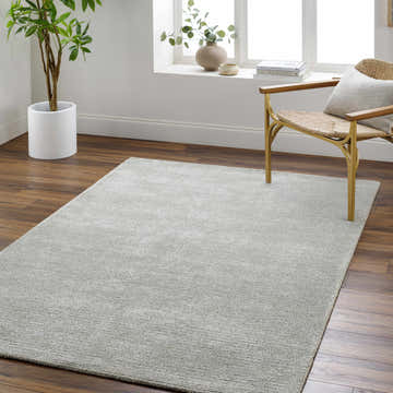 Living room scene with a silver Makya Area Rug, wood floors, chair, and natural light. Roomscene-Rectangle