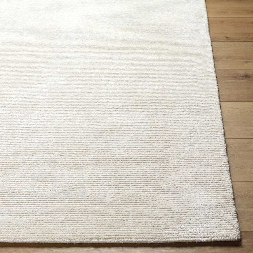Close-up of the hand-tufted Nazih Area Rug. Light silver and off-white viscose rug with subtle horizontal texture. Front