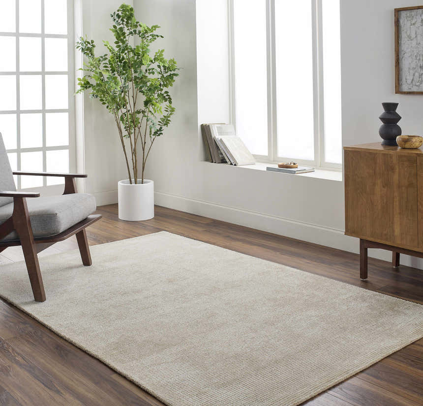 Living room scene with ash Pirro Premium Wool Blend Rug, gray chair, wood cabinet, and natural light. Roomscene-Rectangle