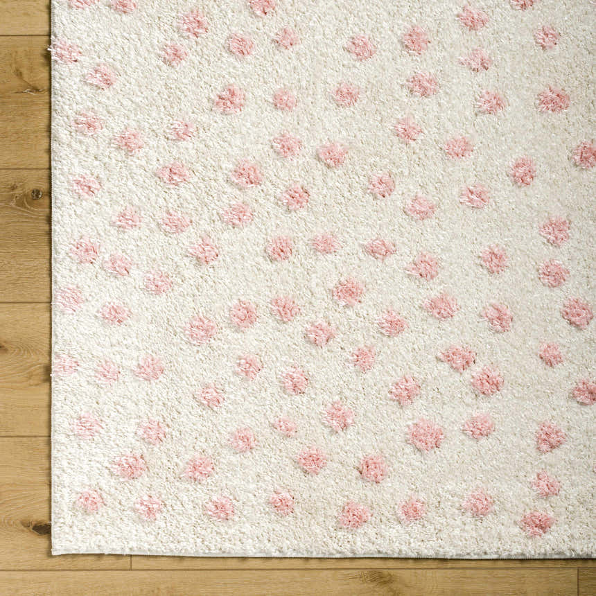 Close-up of the Bernt Beige Area Rug, a soft, textured rug with pale pink tufted dots on a beige background. Corner