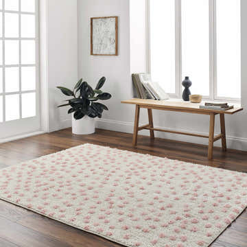 Bright room scene with a Bernt Beige Area Rug featuring pale pink dots on hardwood floors. Roomscene-Rectangle