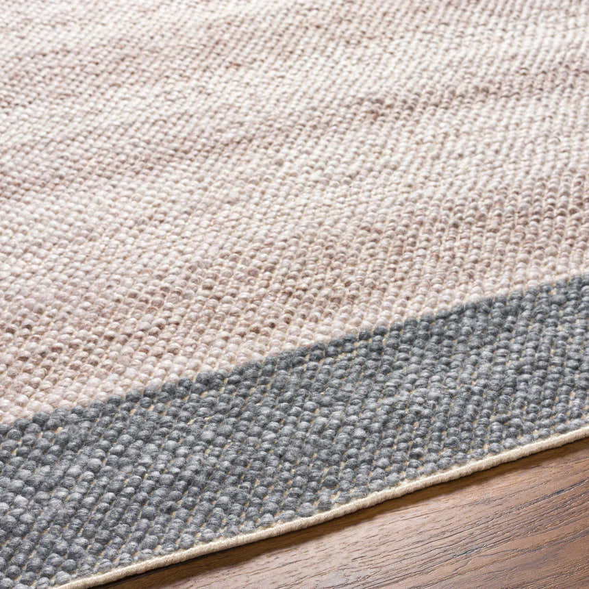 Close-up of the hand-woven Edwin Area Rug showing gray and lambswool recycled PET yarn texture and construction. Texture