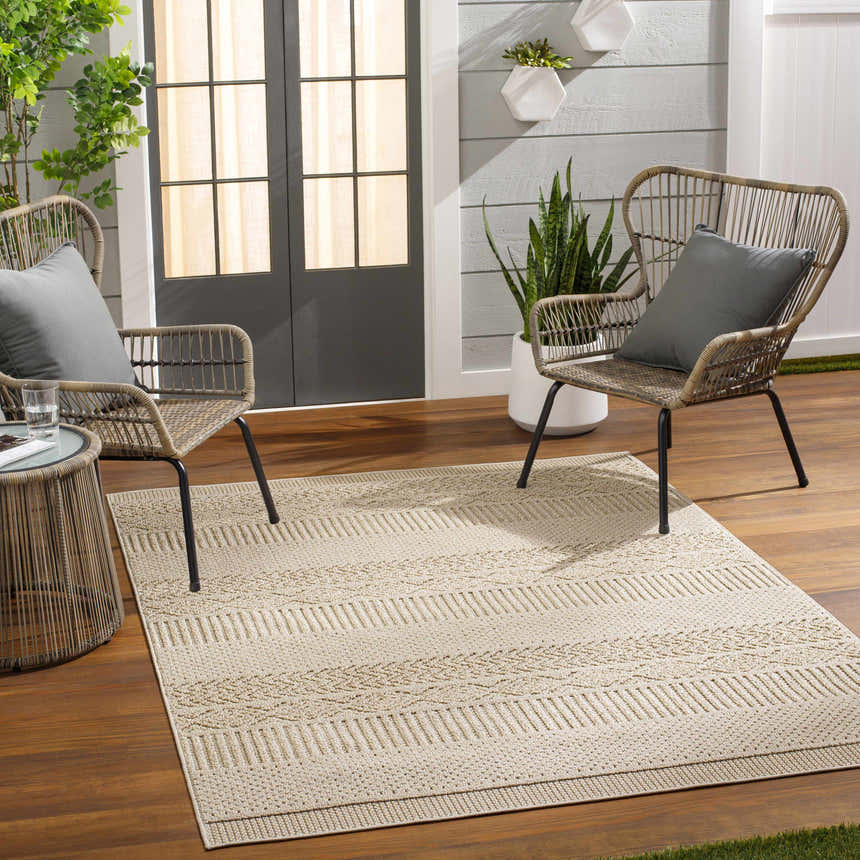 Outdoor patio scene with wicker chairs and Corom Beige Area Rug, creating a cozy and inviting space. Roomscene-Rectangle