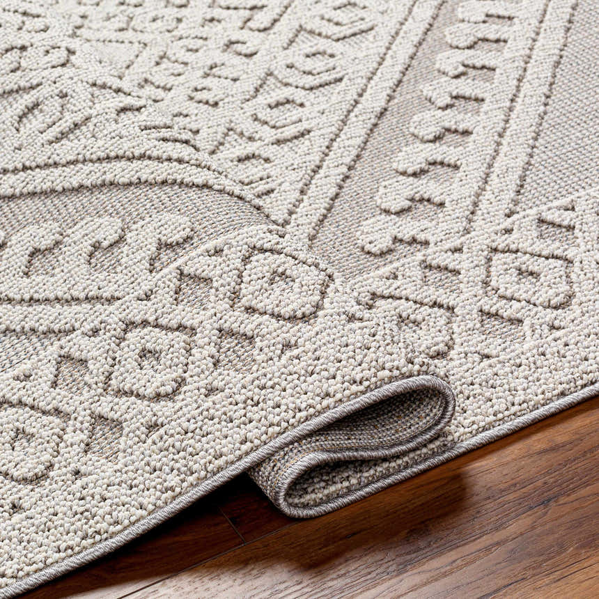 Close-up of the Hibah Natural Gray Area Rug showing its textured, geometric pattern and durable polypropylene material. Fold