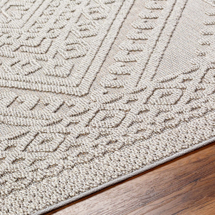 Close-up of the Hibah Natural Gray Area Rug showing its contemporary geometric pattern and textured weave on a wood floor. Texture