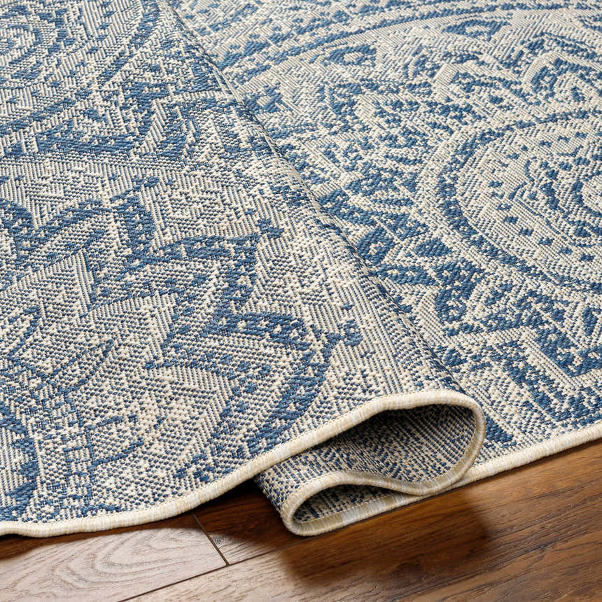 Close-up of the Ayala Blue Durable Rug showing its woven texture and traditional-inspired blue and ivory pattern. Fold