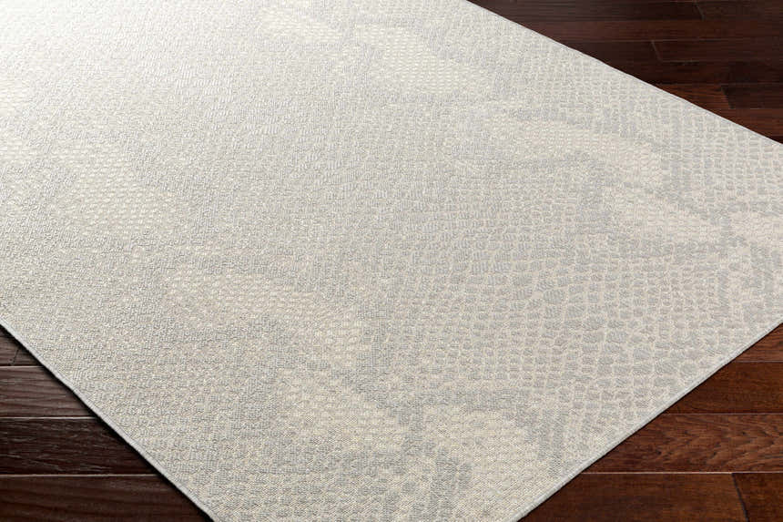 Close-up of the Estee Cream Snake-Patterned Area Rug showing its beige and gray animal print design and textured surface. Corner