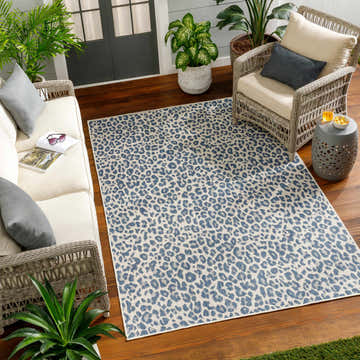Outdoor living room with wicker furniture and Garbo Blue Leopard Print Area Rug. Roomscene-Rectangle