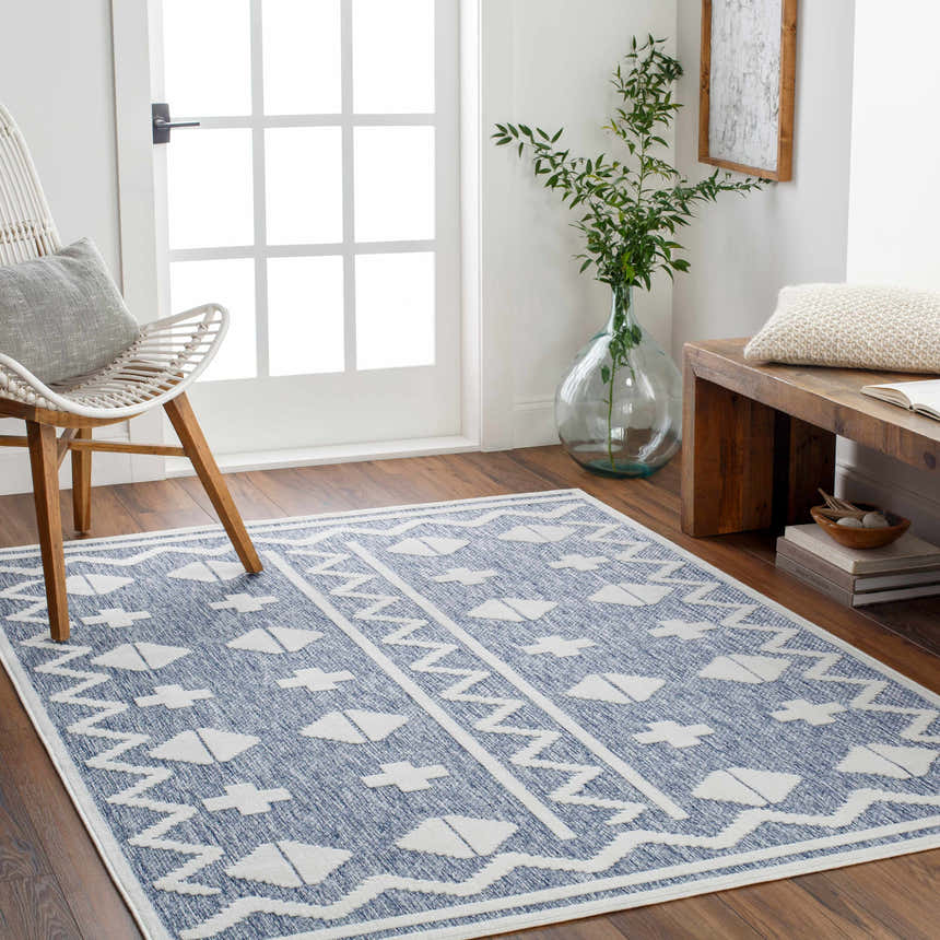 Entryway with Elio Blue Outdoor Rug, white chair, wooden bench, and natural light. Contemporary style. Roomscene-Rectangle