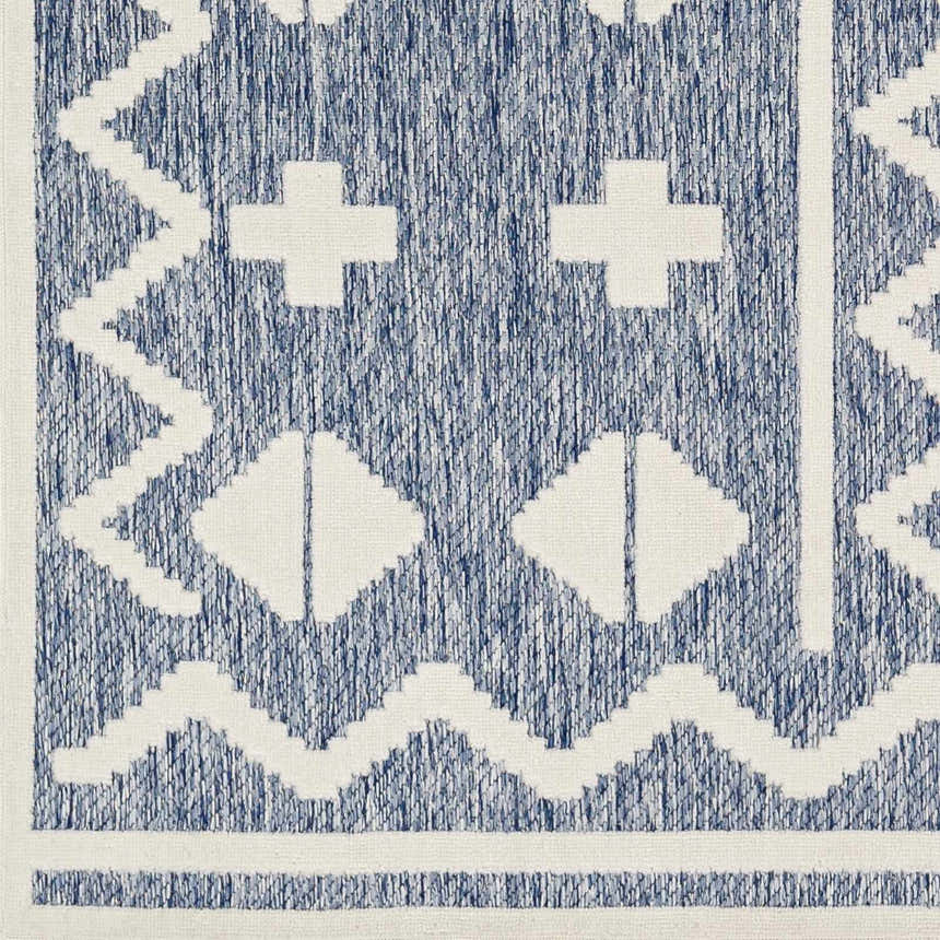 Close-up of Elio Blue Outdoor Rug, featuring a geometric pattern in denim blue and white. Contemporary style. Swatch