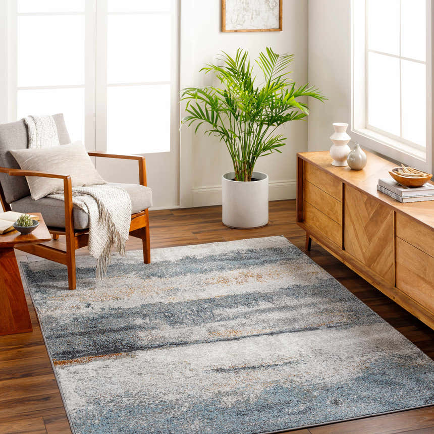 Living room scene with gray chair and Adam Gray Blue Abstract Area Rug on a wood floor. Roomscene-Rectangle