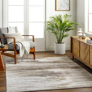 Living room scene with a gray chair and the Derex Area Rug in cloud gray, brown, and nutmeg. Roomscene-Rectangle