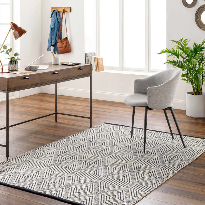 Home office with a dark wood desk and gray chair on a Naya Area Rug with a geometric pattern. Roomscene-Rectangle