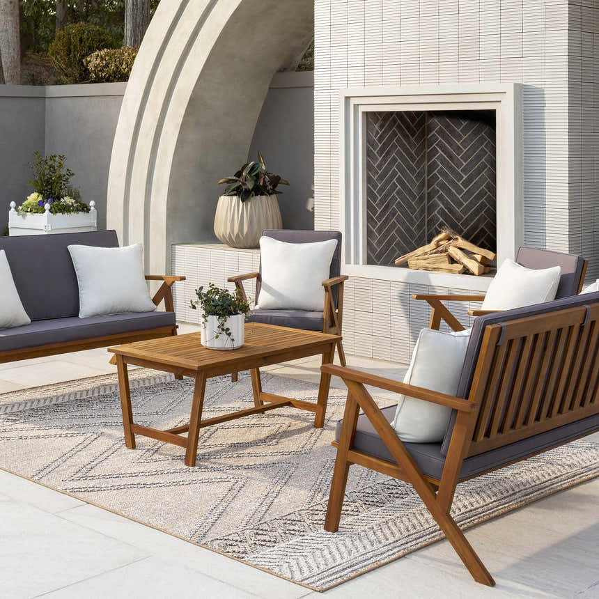 Outdoor patio scene with wood furniture and Beige Areli Area Rug featuring a geometric pattern. Roomscene-Rectangle