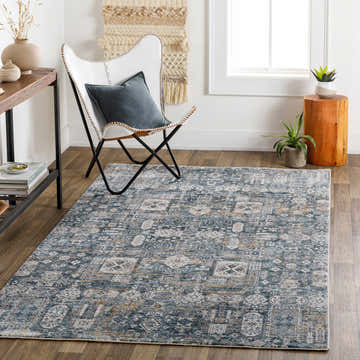 Living room scene with a blue Stacyville Luxe Fringe Rug, white chair, wood accents, and neutral decor. Roomscene-Rectangle