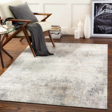 Living room scene with a Standlake Textured Luxe Area Rug in charcoal, cream, and gray under a mid-century modern chair. Roomscene-Rectangle