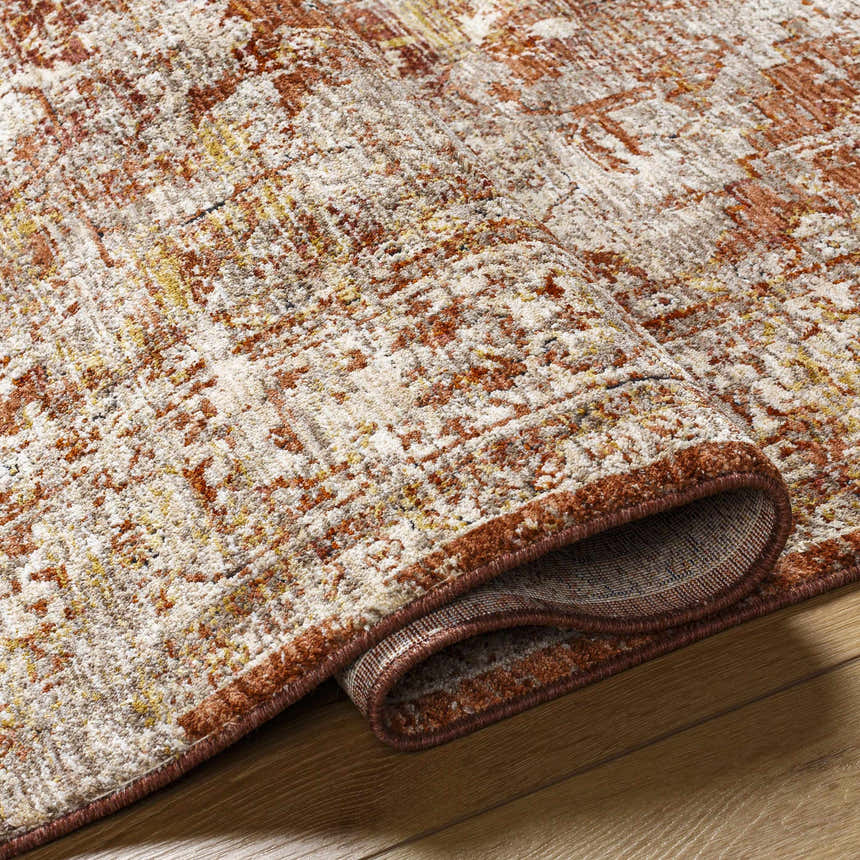 Close-up of the Strathbogie Traditional Red Area Rug showing its brick red, cream, and mustard distressed pattern and texture. Fold