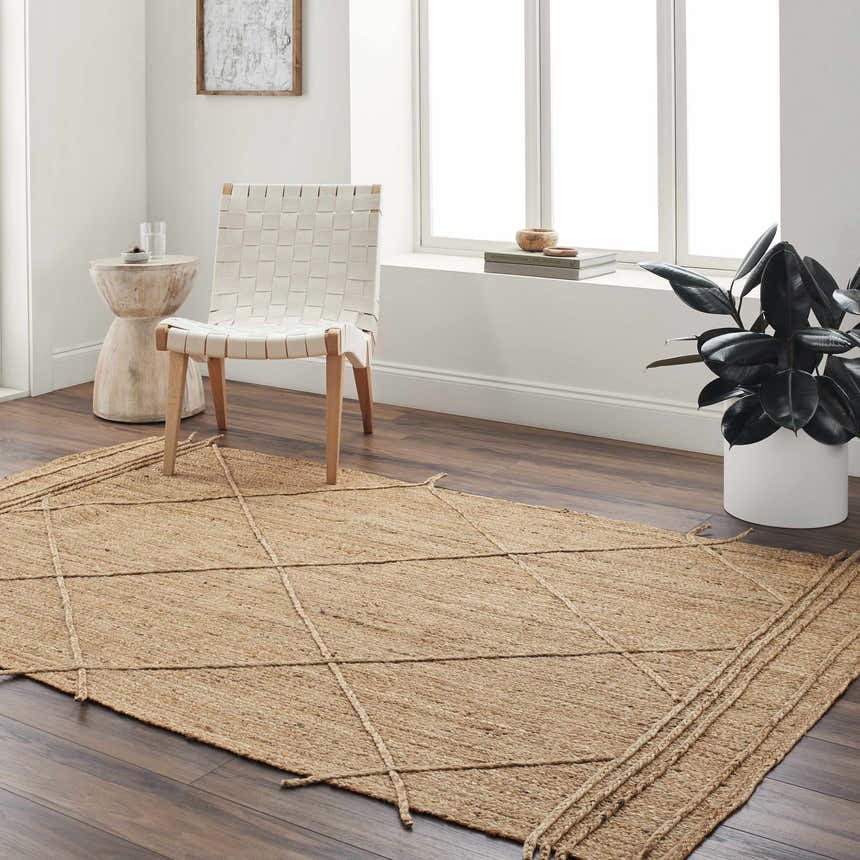 Living room scene with a natural jute Zeno Area Rug, white chair, side table, and dark wood floors. Roomscene-Rectangle