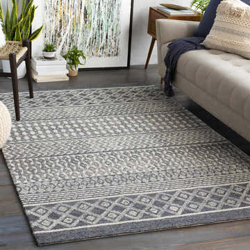 Living room scene with a gray and beige Bohemian Sullivan Area Rug, sofa, and modern art. Roomscene-Rectangle