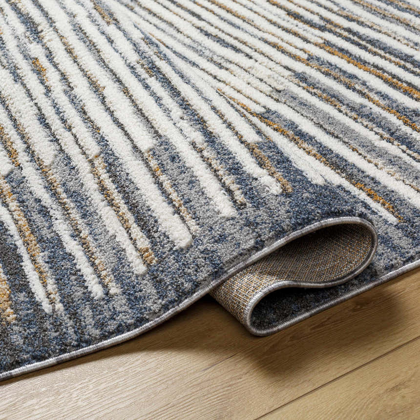 Close-up of Kylar Area Rug featuring a contemporary gray, smoke, and white linear pattern. Rolled edge detail. Fold