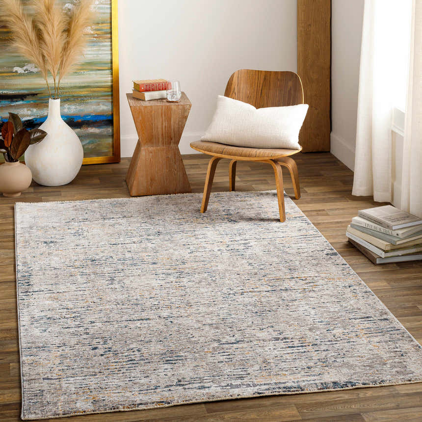 Living room scene with a beige and blue Sywell Luxe Fringe Rug, wood chair, and neutral decor. Roomscene-Rectangle
