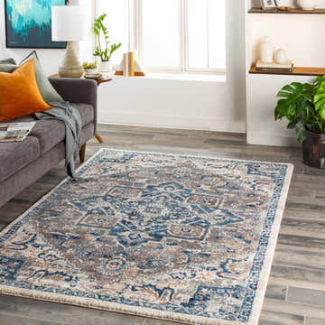 Living room scene with a blue and gray Taligaman Thick Luxe Rug, gray sofa, and wood floors. Roomscene-Rectangle