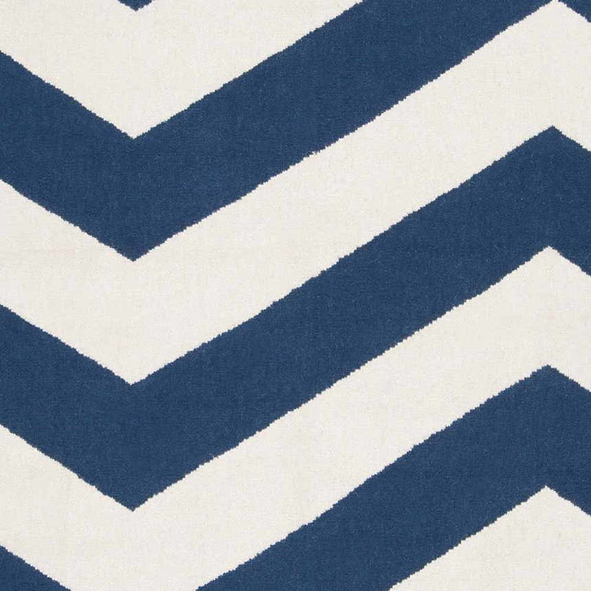 Close-up of the Tamaya Area Rug. Hand-woven wool rug with a bold, dark blue and white chevron pattern. Swatch