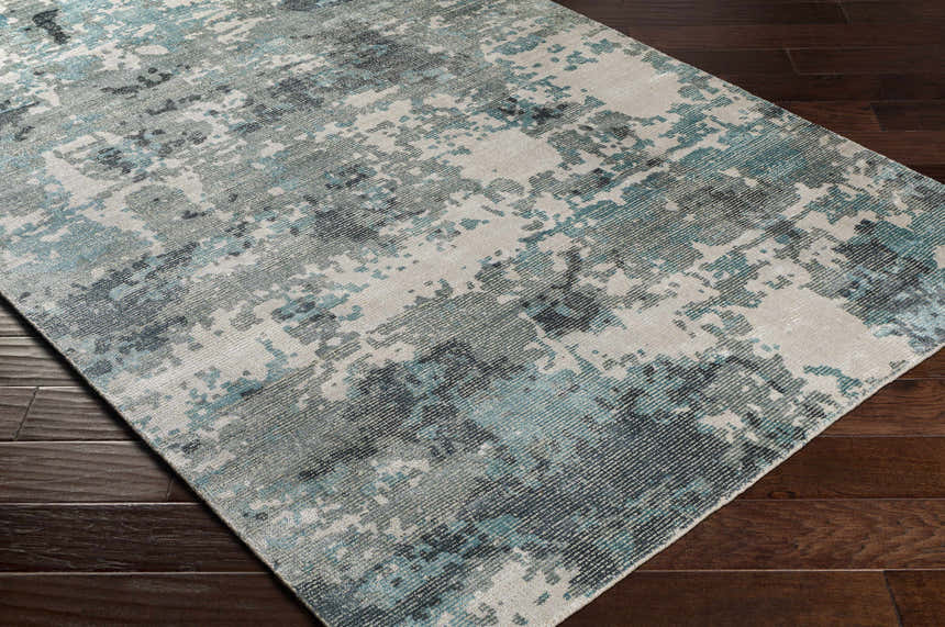 Close-up of Tannersville Area Rug: beige, sage, and teal contemporary design on dark wood floors. Corner