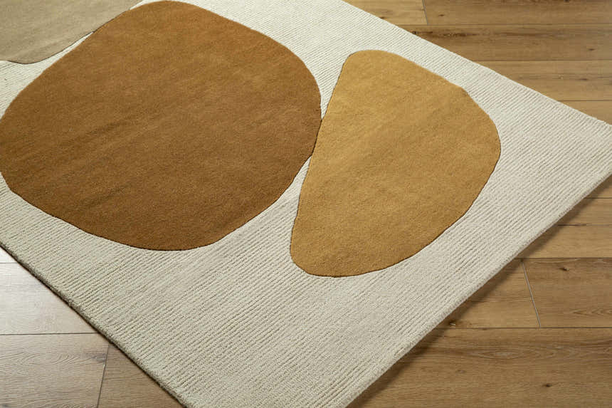 Close-up of the Tutti Area Rug featuring tan and brick red abstract shapes on a sterling gray wool base. Contemporary style. Corner