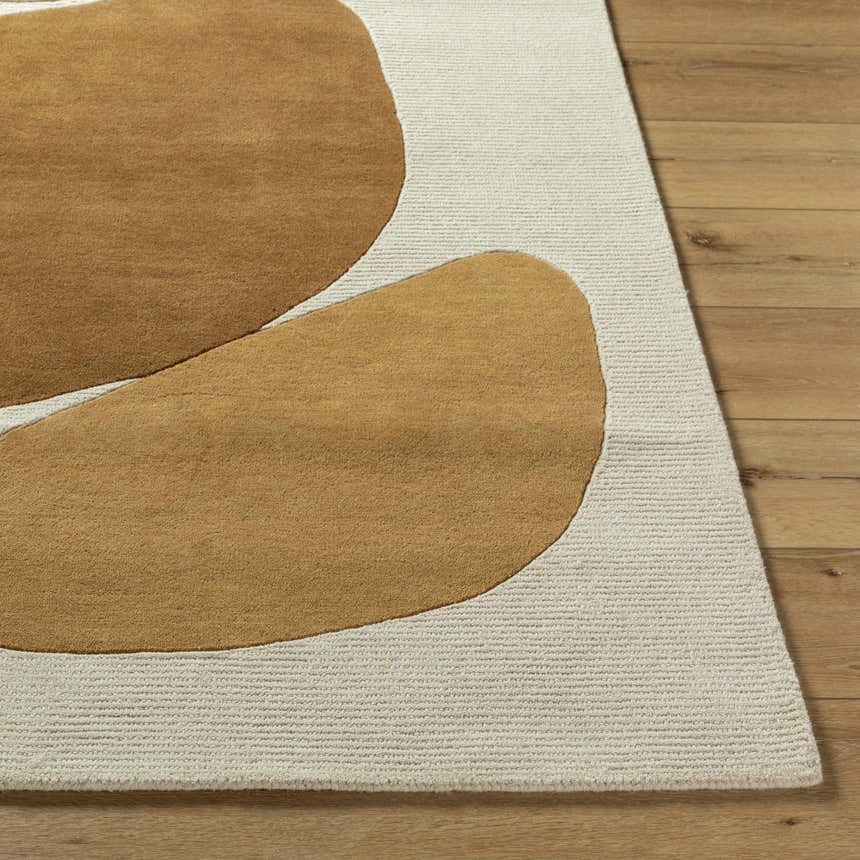 Close-up of the hand-tufted Tutti Area Rug. Tan organic shapes on a textured, sterling gray wool rug. Contemporary style. Front