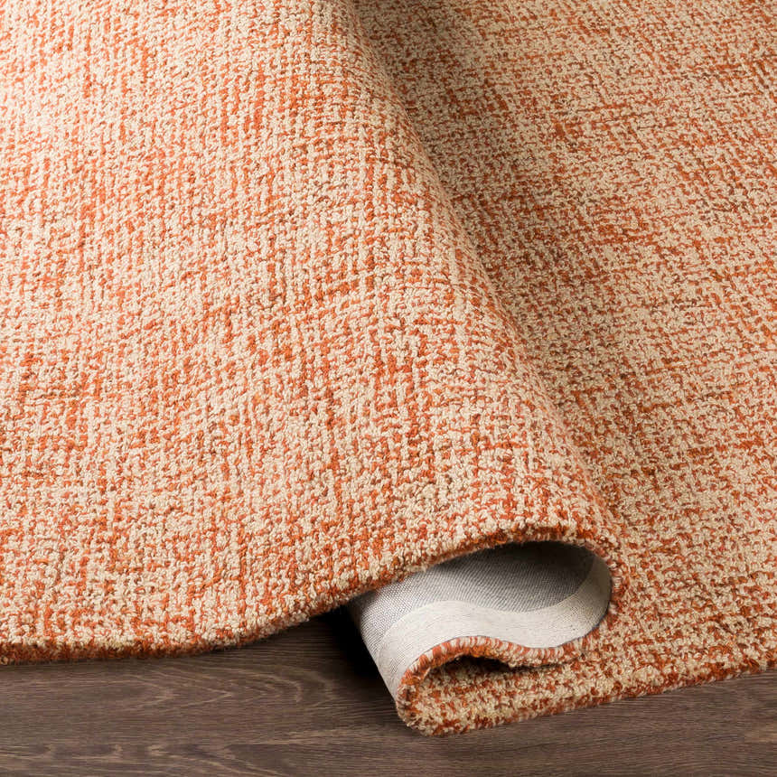 Close-up of the hand-tufted Teresita Area Rug. Burnt orange and ivory wool rug with a textured, contemporary design. Fold