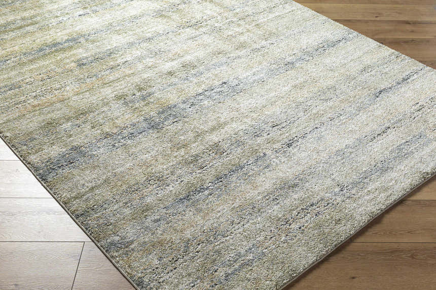 Close-up of the Taran Thick Luxe Rug. Contemporary design with light gray, olive, peach, and tan hues. Soft texture. Corner